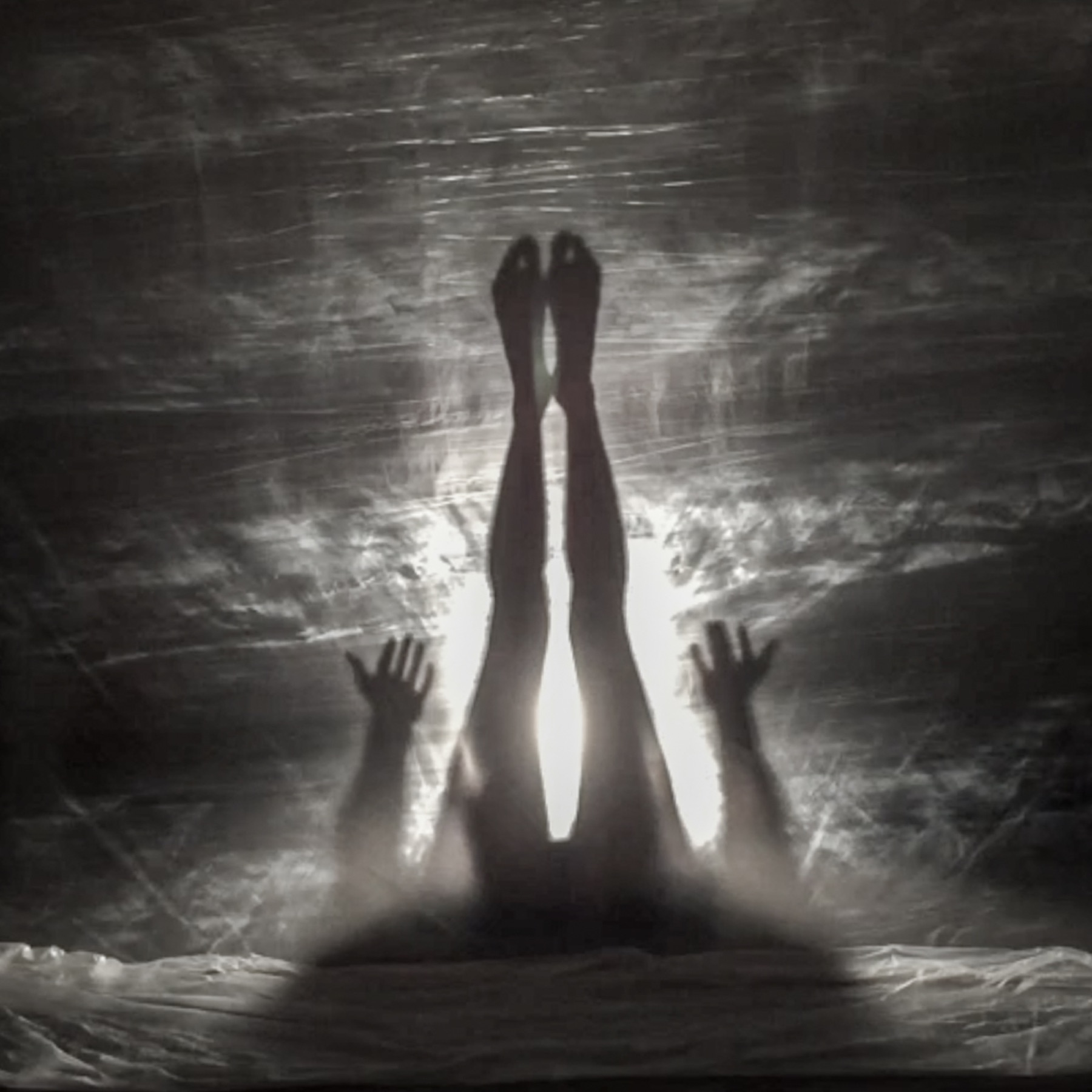 Arms rising vertically through light and shadow