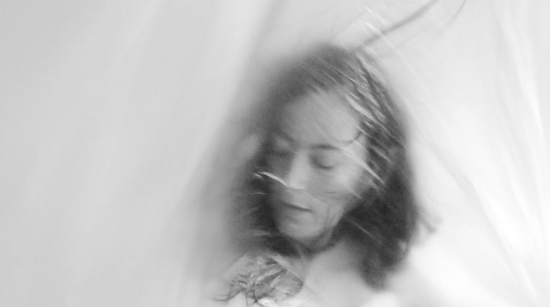 Still from Un-veil: figure seen through translucent material