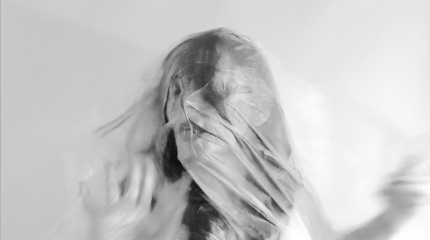 Still from Un-veil: face emerging from translucent material